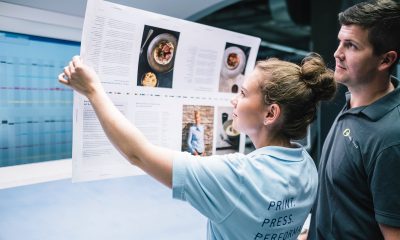 Mitarbeiter gehen ihrem Jobs in Röbel in der Druckerei bei optimal media nach und prüfen Proofs