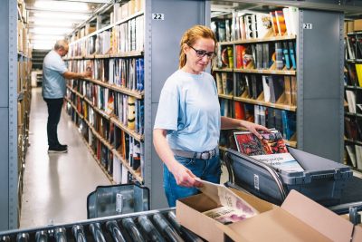 Mitarbeiterin verpackt die Schallplatte in die passende Verpackung zum Versand im Vinyl Presswerk von optimal media in Röbel