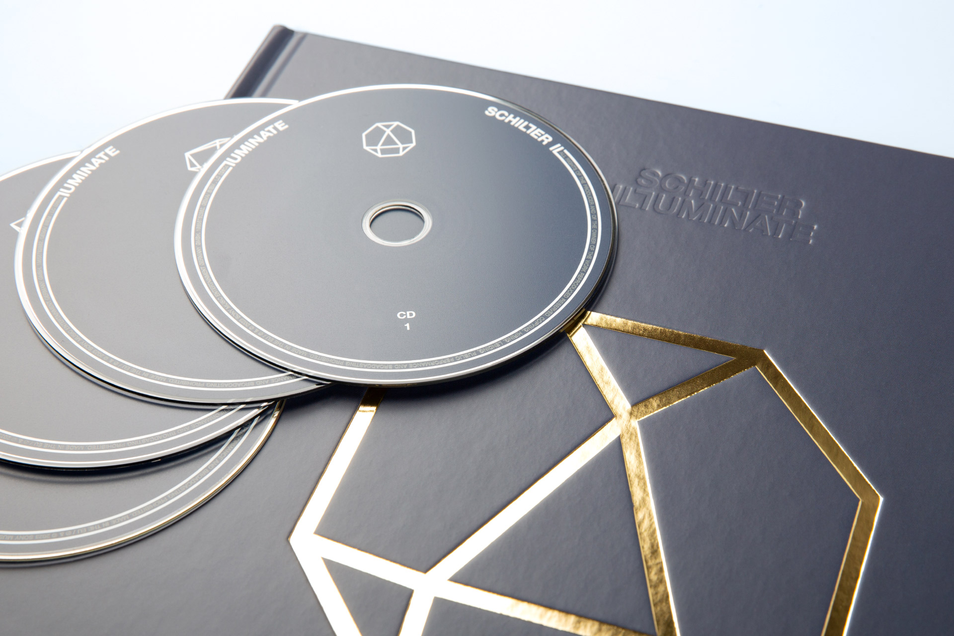 SCHILLER – ILLUMINATE | Sony Music: Filigrane Tief- und goldene Heißfolienprägung auf U1