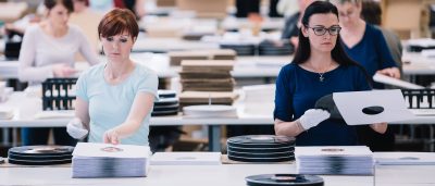 Service fulfillment bei optimal media Mitarbeiter bei der Handverpackung von Schallplatten für portooptimierten Mailing-Service