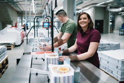 optimal media Druckverarbeitung zwei Mitarbeiter bei der Bestückung der Fadenheftmaschine in der Buchstrasse