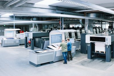 Zwei Spezialisten von optimal media für Druckerei und Buchbinderei im Drucksaal für Bogenoffsetdruck